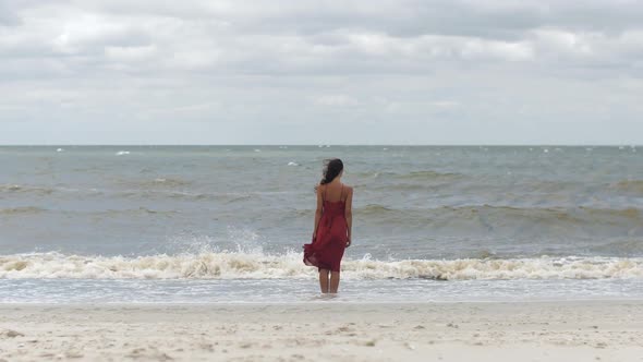 Woman in a Red on the Beach Cold Windy Weather