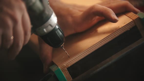 Carpentry Industry- Man Worker Drilling the Holes in Plywood