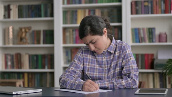 Indian Woman having Disappointment while Writing on Paper