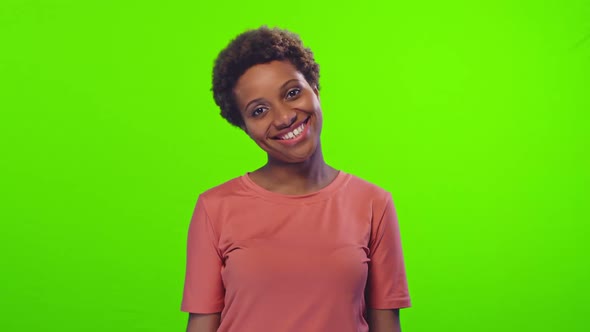 Attractive Young African American Woman Winks and Shows Thumb Up on Chroma Key