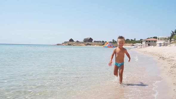 Beautiful Landscape of Azure Sea Blue Sky and a Boy Running Along the Beach on a Sunny Day