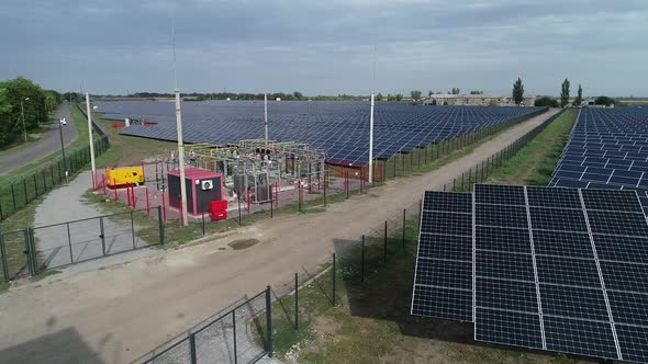 Sunny Day in the Field with a Huge Solar Power Station Panels and Transformer