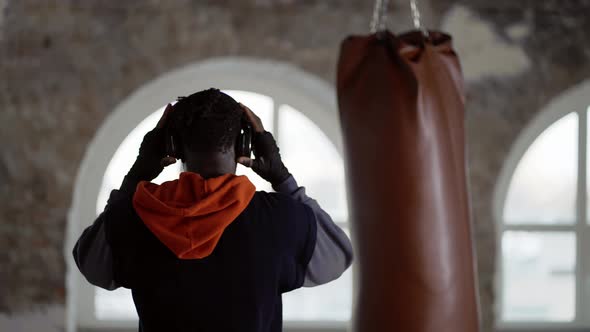 Professional Boxer Putting on Headphones Warming Up Before General Training