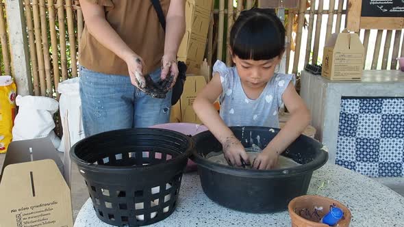 Asian Child girl mingles ducks eggs with mix salty paddy husk, girl prepare duck eggs to be preserve