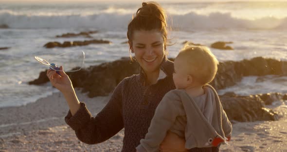 Mother and baby boy playing with bubble wand 