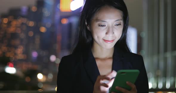 Business Woman Reading on Mobile Phone at Night 