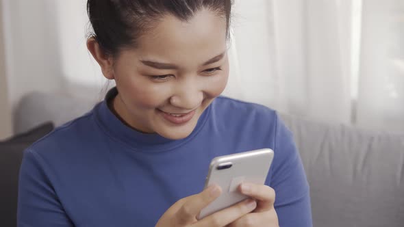 Asian woman on using a smartphone with AI voice command for a chat with customer