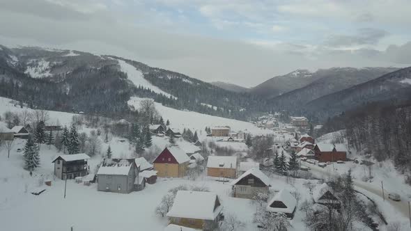 Aerial View of a Car Moving on Winter Road in Carpathian Village To the Ski Resort Pilipets. Bird's