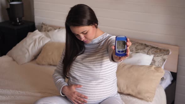 Pregnant Woman Showing Glucose Meter with Result of Measurement Sugar Level