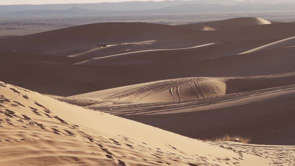 Tourists Riding Camels In Sand Dunes Of Desert