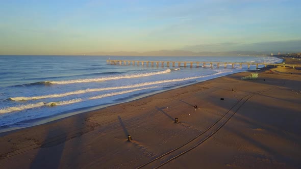 Aerial drone uav view of a lifeguard tower, pier, beach and ocean.