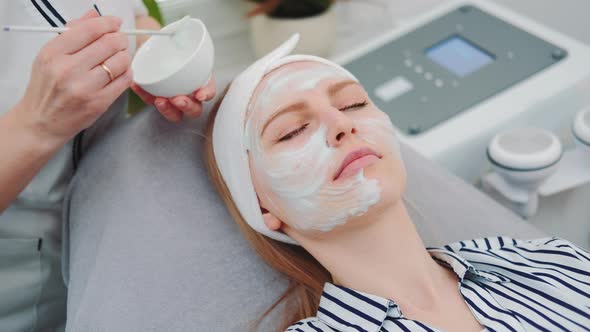 Medium Shot of Beautician Putting Cream Mask on Woman's Face at Beauty Salon