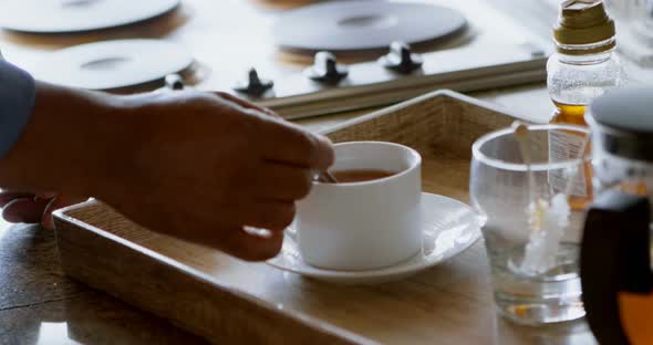 Senior man stirring coffee in the kitchen 4k