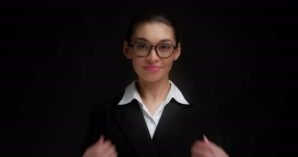 Businesswoman in Glasses and a Black Jacket Shows a Come Here Hand Gesture