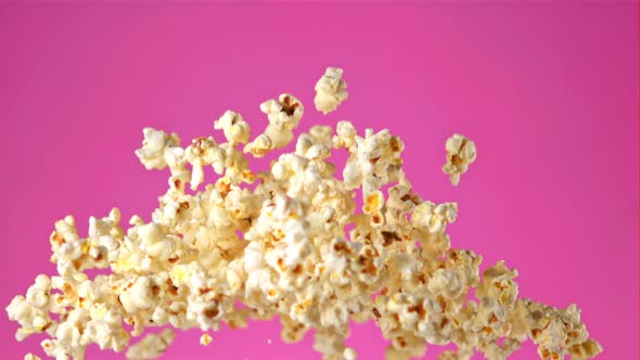 Super Slow Motion Popcorn Flies on a Pink Background