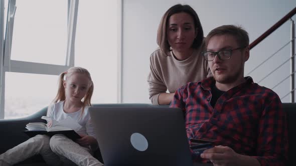 Family Making Online Shopping While Man Holding Computer and Ba