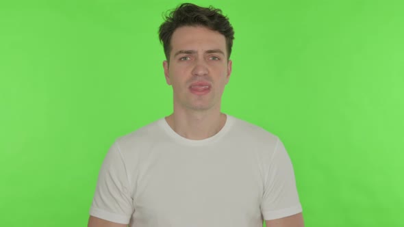 Young Man Shouting and Screaming on Green Background