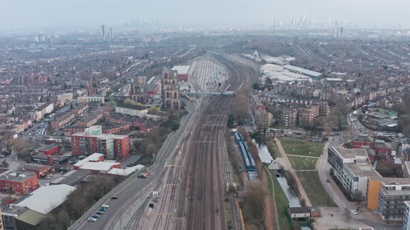 Drone shot over dense train tracks heading into London