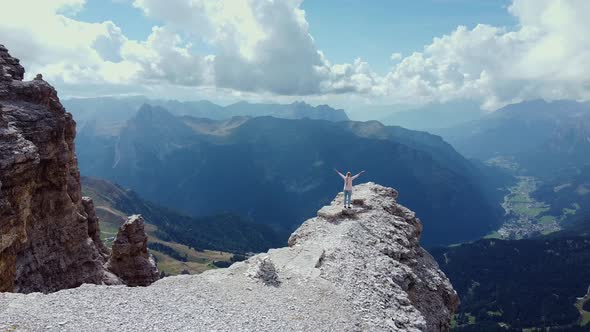 Aerial View of Woman with Raised Hands Proudly Standing on Piz Boe Mountain Top