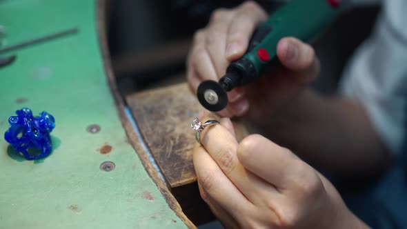 Closeup Female Hands Polishing Gemstone on Ring with Tool in Slow Motion