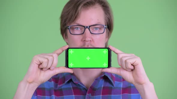 Face of Young Handsome Hipster Man Showing Phone
