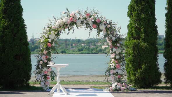 Place for bridal ceremony in white color against the background of the river. Wedding arch