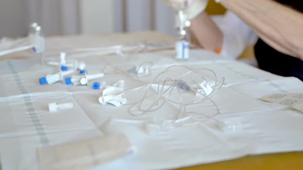 Middle aged woman preparing vials of antibiotic solution with tubes and various medical equipment st