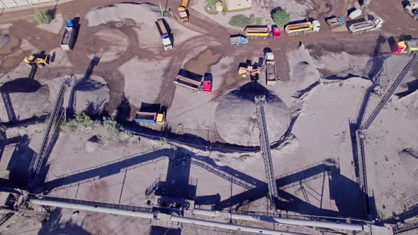 Excavators and Tractors Load Crushed Stone and Rock Into Dump Trucks