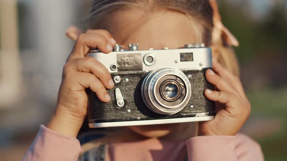 Little pretty girl with a retro camera