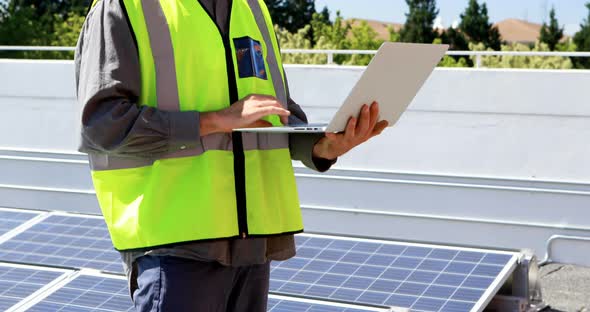 Male worker using laptop at solar station 4k