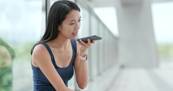 Woman Sending Audio Message on Cellphone in City