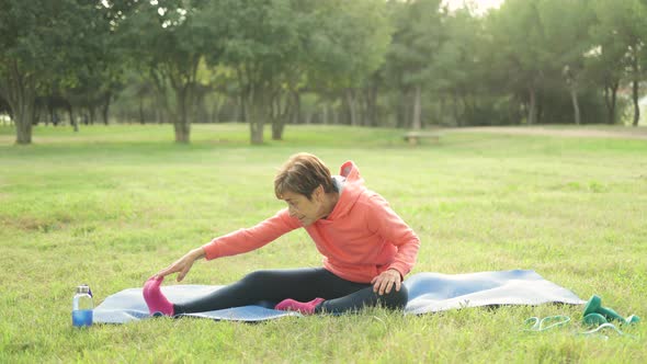 Senior Woman Doing Yoga Sport Routine Outdoor at Park