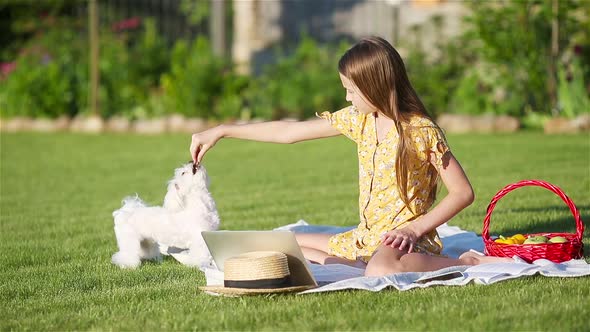 Little Smiling Girl Playing with Puppy in the Park