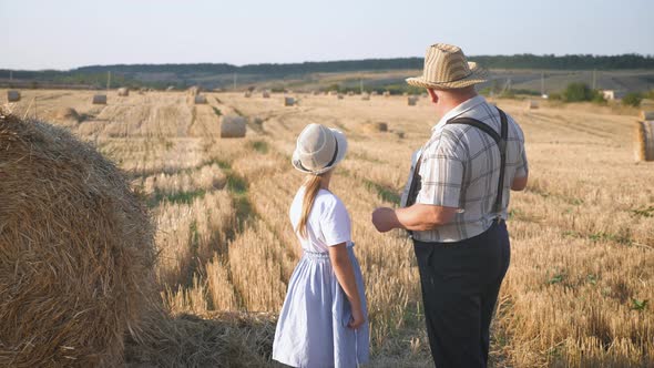 Little Girl with Grandfather in Field Haystacks, Grandfather Farmer Is Teaching the Younger