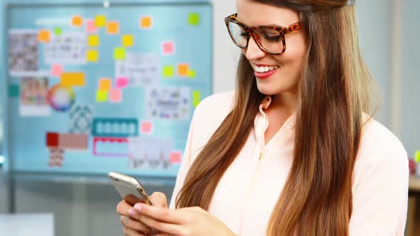 Female executive using mobile phone in office