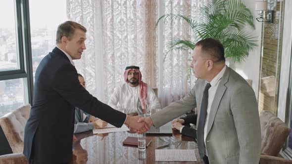 Middle-Aged Business Men Shaking Hands At Conference