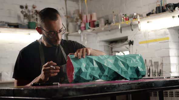 Close-up: a man works with a blade. Production of decorative elements. Workshop.