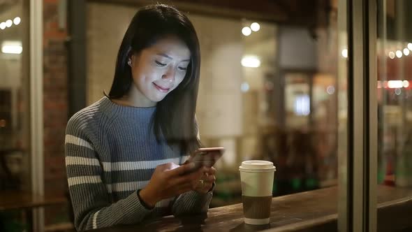 Woman using tablet pc at coffee shop at night