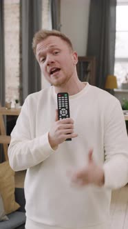 Vertical Portrait of Guy Rapping into TV Remote