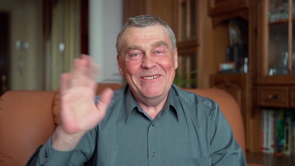 POV slow motion close up shot of senior man looking at camera talking and smiling at home indoors