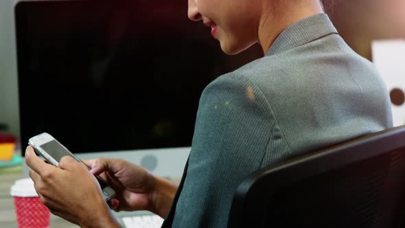 Businesswoman using mobile phone in office