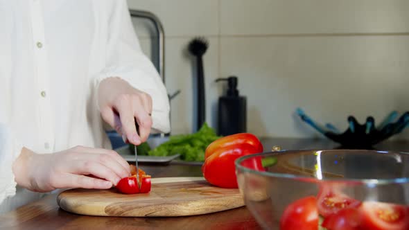 Woman Slicing Bell Pepper at Chopping Board on Kitchen Counter Indoors