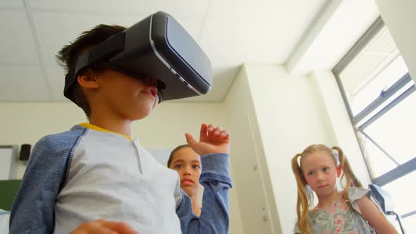 Schoolboy using virtual reality headset in classroom at school 4k