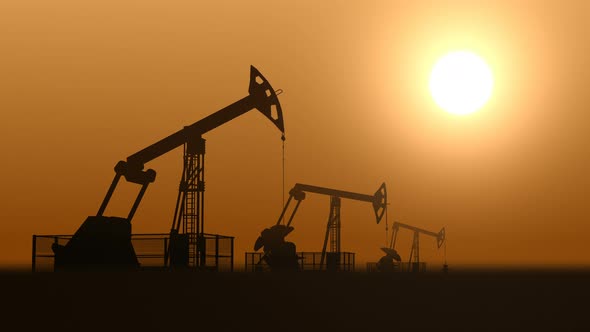 Oil Pump Jacks in the Desert Extracting Crude Oil against Sunset 