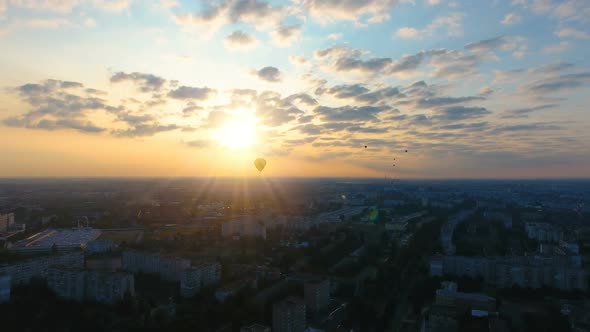 Many hot air balloons floating in distance against setting sun, beautiful view