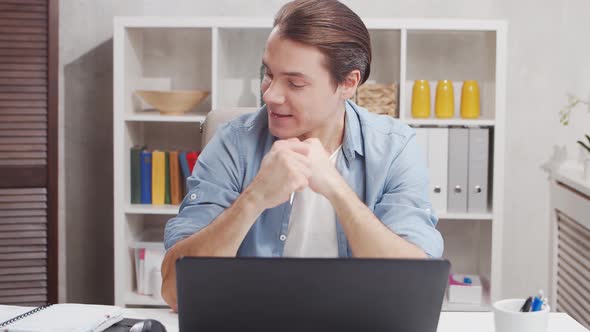 Workplace of freelance worker at home office. Young man works using computer.