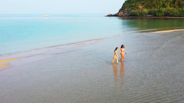 Tourists tanning on relaxing coastline beach voyage by transparent ocean with white sand background 