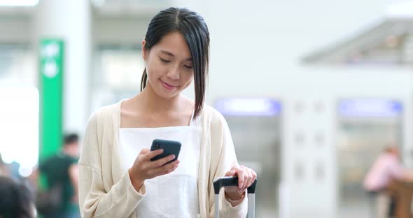 Woman holding smart phone in the airport