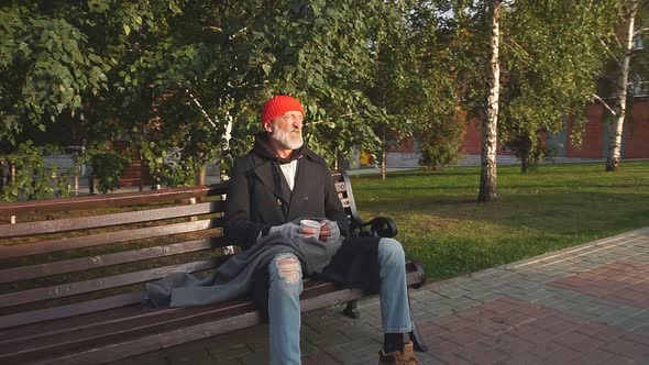Mature Man Without Shelter Sitting in Street Clothes on Bench, Without Food and Money.