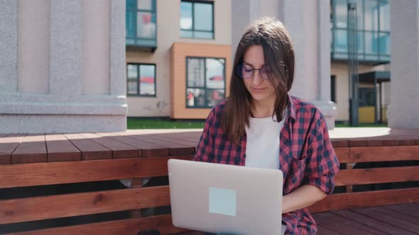 Young Woman Working on Solving Computer Thinking Problem Outdoors